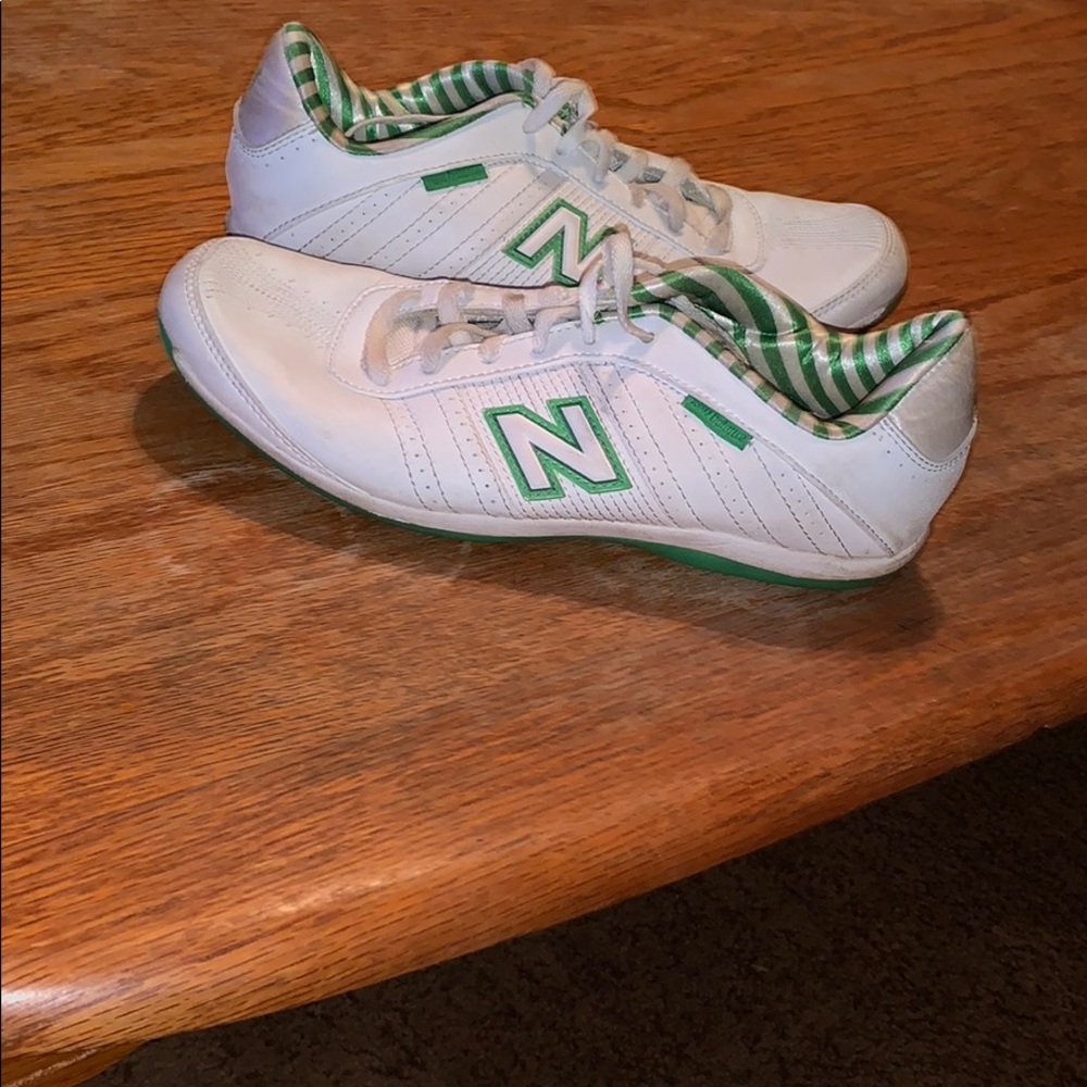 Green and white new balance tennis shoes.